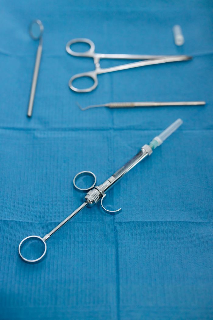 About Detailed image of dental instruments including a syringe on a blue surface, emphasizing dental care.